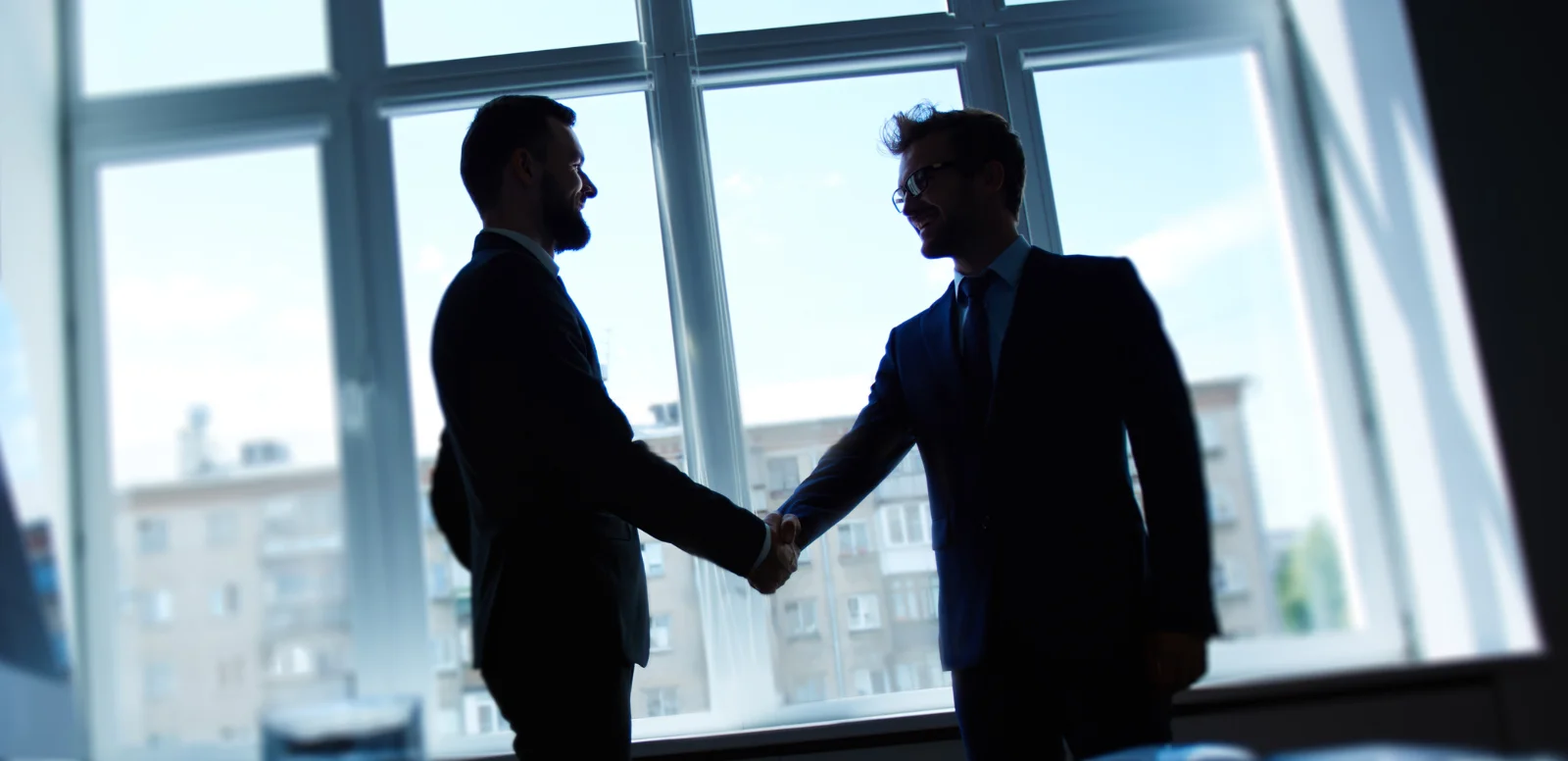 Two people shaking hands in office space